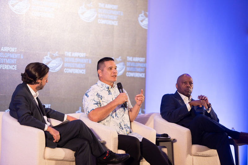 Three panelists in discussion on stage at ADIC 2026