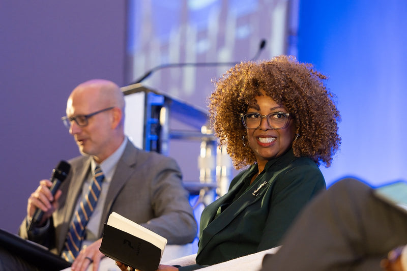 Panelists in conversation on stage at ADIC 2026