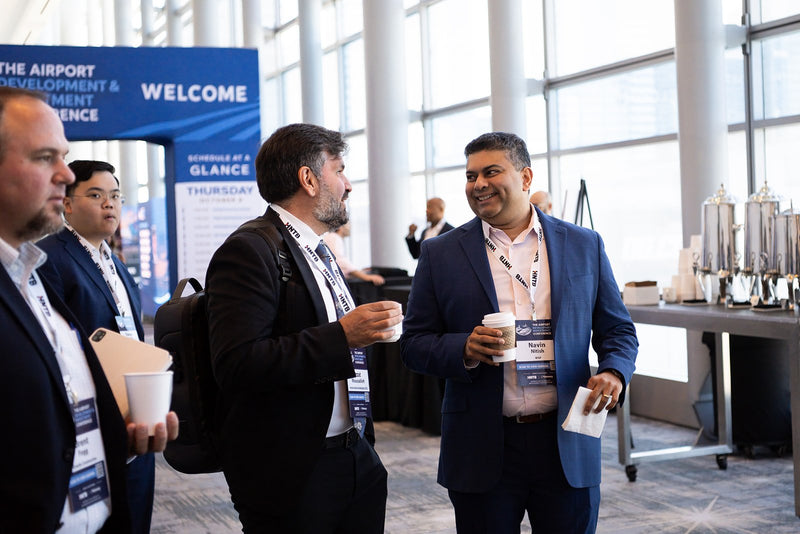 Attendees chatting over coffee in the foyer at ADIC 2026