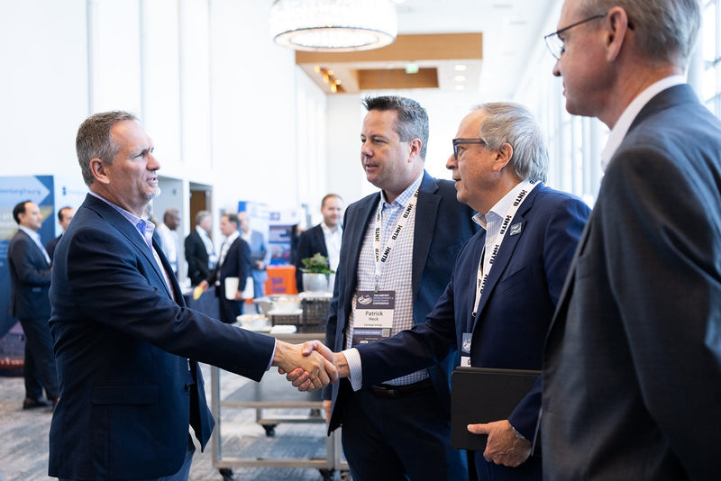 Attendees greeting each other with a handshake at ADIC 2026