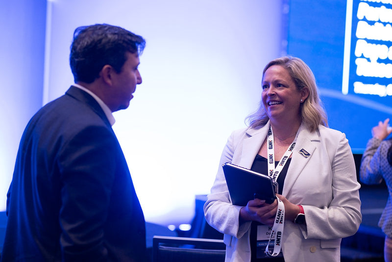 Attendees in conversation near the main stage at ADIC 2026