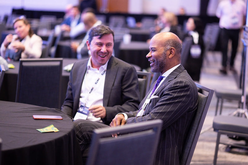 Attendees sharing a laugh at a table at ADIC 2026
