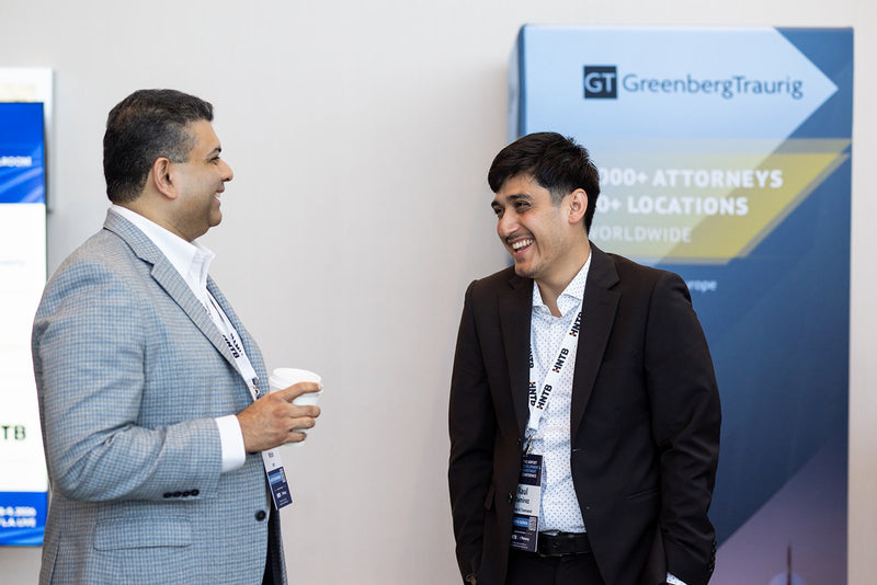 Two attendees laughing in the expo hallway at ADIC 2026