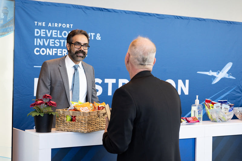 Attendees chatting at the registration desk at ADIC 2026