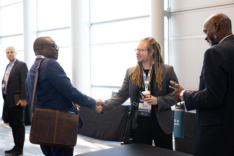 Attendees shaking hands in the foyer at ADIC 2026