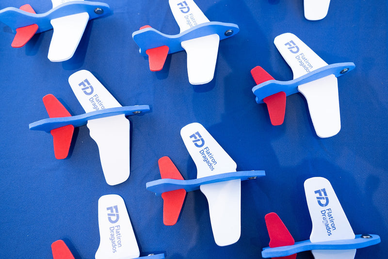Branded model airplane giveaways at an exhibitor table at ADIC 2026