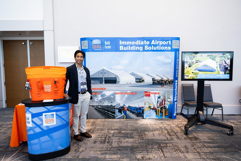 Exhibitor standing at a booth in the expo area at ADIC 2026