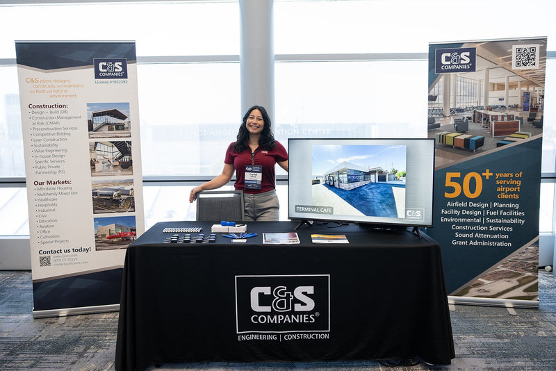 Exhibitor welcoming visitors at a booth at ADIC 2026