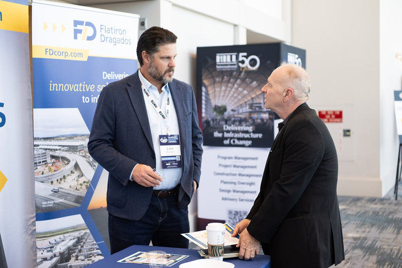 Attendees in conversation at an exhibitor booth at ADIC 2026